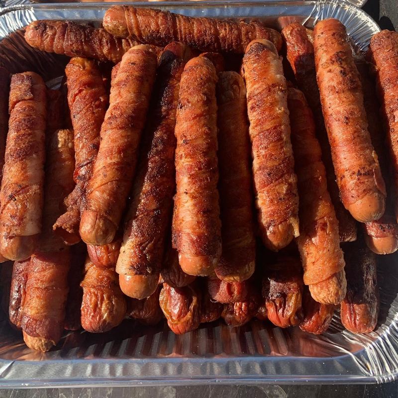 Bacon-wrapped hot dogs on the grill