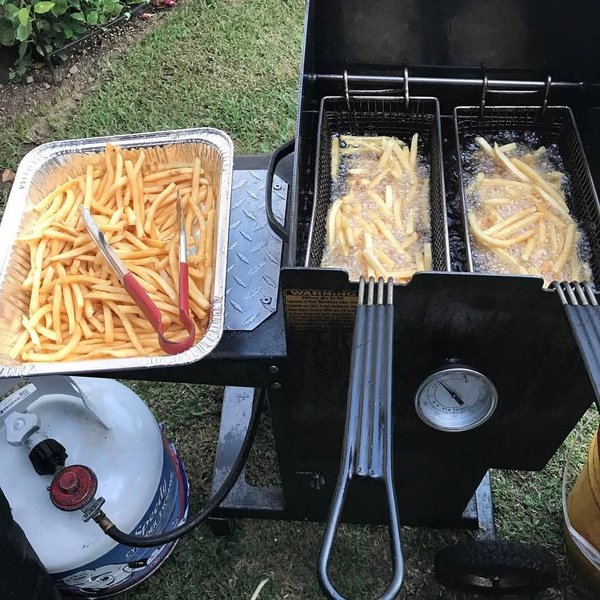 Fresh fries in a tray next to the fryer